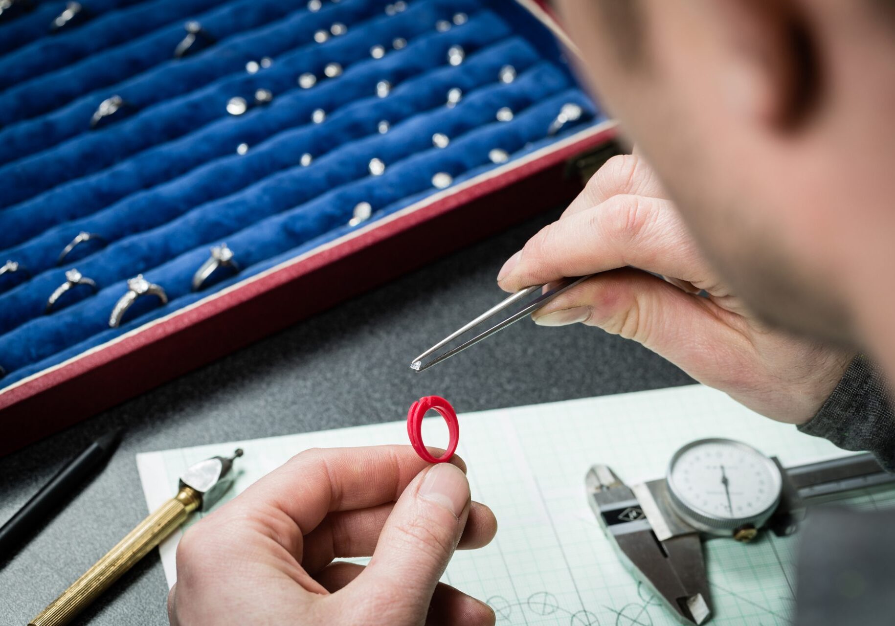 Jeweler working with wax model ring in his workshop. Craft jewelery making.